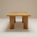 Teak dining table on a beige and off-white background