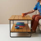 Person setting a mug on the slatted teak coffee table