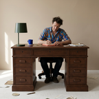 Person writing at the classic teak wood desk