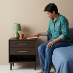 Person placing a book on the espresso teak nightstand